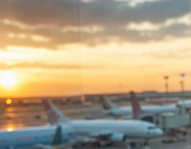 Airport window at sunset with parked airliners on the apron